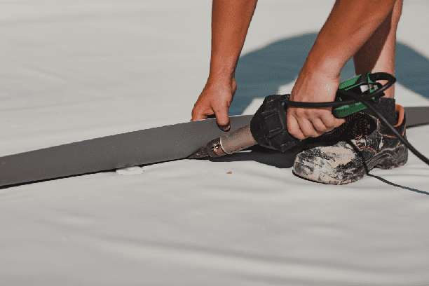 a person using a drill to cut a piece of paper